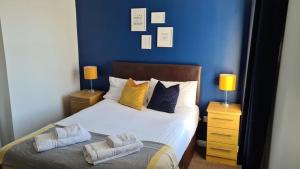 a bedroom with a bed with blue walls and two lamps at The Davron Hotel in Fraserburgh