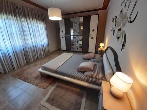 a bedroom with a bed and a large window at casa Guanita in Uzzano
