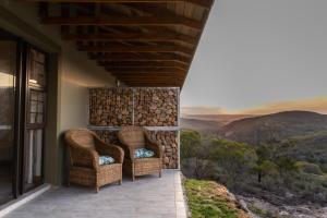 two wicker chairs sitting on a porch with a view at Pabala Private Nature Reserve in Hankey