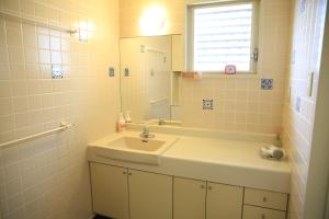 ein Bad mit einem Waschbecken und einem Spiegel in der Unterkunft Shinnishiki Hotel in Shirahama