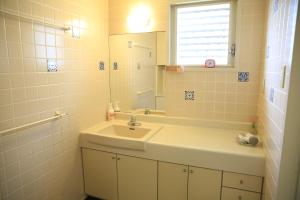 a bathroom with a sink and a mirror at Shinnishiki Hotel in Shirahama