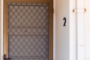 a door with a gate with a number on it at West Beach Family Beauty - 2 Bed Unit in Henley Beach South