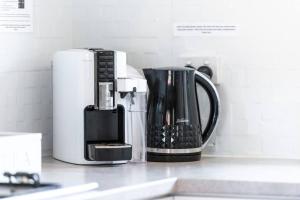 a kitchen counter with a coffee maker and a coffee pot at West Beach Family Beauty - 2 Bed Unit in Henley Beach South