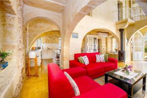 un soggiorno con divano rosso e tavolo di Gawhra Holiday Home a Xagħra