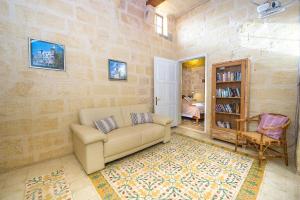 ein Wohnzimmer mit Sofa und Bücherregal in der Unterkunft Gawhra Holiday Home in Xagħra