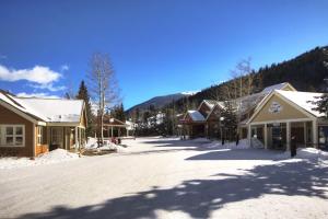 a snow covered street in a small town with houses at Slopeside in Keystone