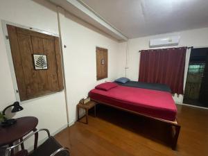 um quarto com uma cama com um cobertor vermelho em Hidden Lumpu em Bangkok