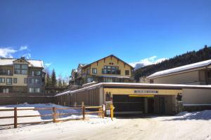 a building with a parking lot in the snow at Slopeside in Keystone