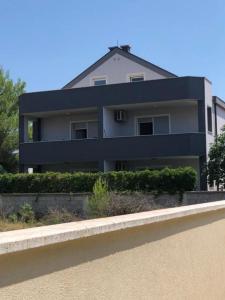 a white house with a black roof at Apartment MiaAntonia in Vrsi