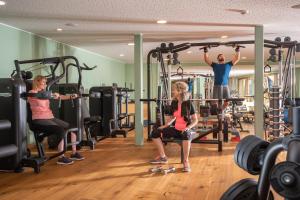 a group of people in a gym doing squats at Tratterhof Mountain Sky Hotel in Maranza