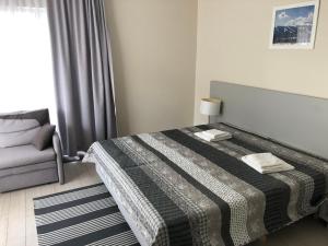 a bedroom with a bed and a chair and a window at Apartament studio Czarna Góra II in Sienna