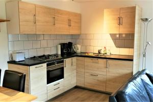 a kitchen with wooden cabinets and a stove top oven at Vakantiehuis Domburg 100 meter van het strand - veel privacy - eigen parkeerplaats. in Domburg
