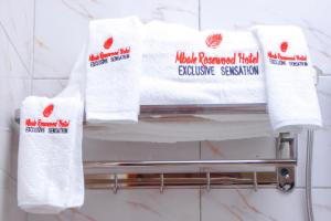un mucchio di asciugamani su un portasciugamani in bagno di Mbale Rosewood Hotel a Mbale