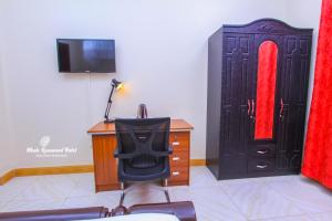 a room with a desk and a chair and a television at Mbale Rosewood Hotel in Mbale