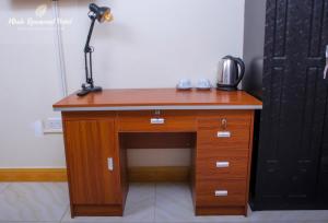una scrivania in legno con una lampada sopra di Mbale Rosewood Hotel a Mbale