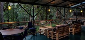 un patio con mesa, sillas y árboles en Kizumba House, en Arusha
