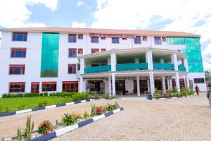 a large white building with a lot of windows at Mbale Rosewood Hotel in Mbale