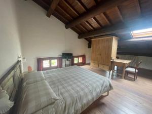 Albaspina BioAgriturismo في Monticello Conte Otto: غرفة نوم بسرير كبير ومكتب