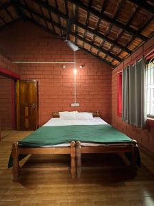 um quarto com uma cama numa parede de tijolos vermelhos em MID BEACH STAY Gokarna em Gokarna