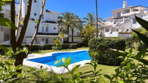 une villa avec une piscine en face d'un bâtiment dans l'établissement SERINAMAR- Los Naranjos de Marbella, à Marbella