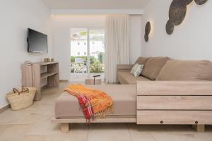 a living room with a couch and a tv at Seaclub Alcudia Mediterranean Resort in Port d'Alcudia