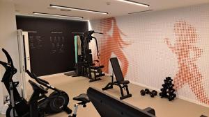a gym with several exercise equipment in a room at HG Jardín de Menorca in Son Bou