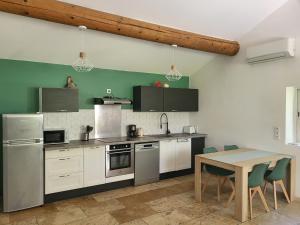 een keuken met witte apparatuur en een houten tafel bij Mas de Guinot in Villeneuve