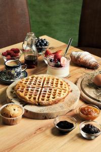 a wooden table topped with a waffle and fruit at Hotel Salvadori in Mezzana