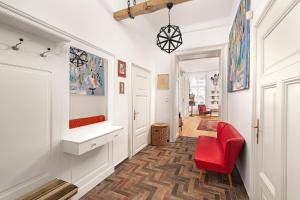 un corridoio con una sedia rossa in una stanza di BonBon Style Apartman Budapest a Budapest
