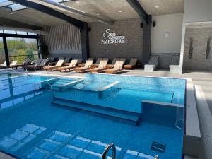 a large swimming pool with chairs in a building at SPA Kompleks Raiski Kat in Dimitrovgrad