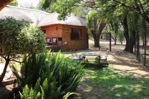 a small brick building with a picnic table in a yard at Khaya Africa Guesthouse in Midrand