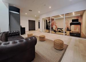 a living room with a black leather couch and stool at HG Jardín de Menorca in Son Bou