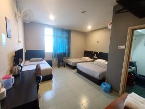una camera d'albergo con due letti e una finestra di Winton Hotel a Mentekab