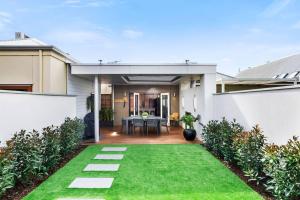 a house with a green lawn in the backyard at Cute as a Button - Picket Fence 3 Bed Stylish Home in Unley