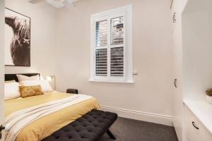 a bedroom with a bed and a window at Cute as a Button - Picket Fence 3 Bed Stylish Home in Unley