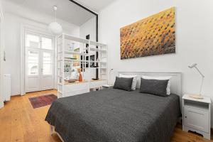 una camera da letto con un letto e un dipinto sul muro di BonBon Style Apartman Budapest a Budapest