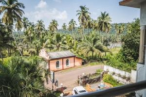a view from the balcony of a house with palm trees at Dhanashree Riverview Hotel in Corgao