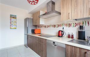 Una cocina con gabinetes de madera y electrodomésticos de acero inoxidable. en Amazing Home In Mielno With Wifi, en Mielno