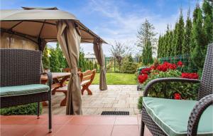 Un patio con una mesa y sillas y una sombrilla. en Amazing Home In Mielno With Wifi, en Mielno