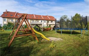 a playground with a slide in a yard with a house at Beautiful Home In Mielno With Wifi in Mielno