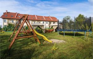 un parque infantil con un tobogán en un patio con una casa en Amazing Home In Mielno With Wifi, en Mielno 23 fotos más