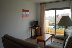 a living room with a couch and a television at Apartamentos Proamar in Torre del Mar