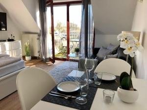 una sala da pranzo con tavolo e sedie e un soggiorno di Ferienwohnung-Mary-Poppins-mit-Balkon-zwischen-Strand-Wald-Wiese-im-Suedosten-der-Insel-Ruegen a Gustow