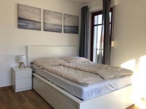 un letto in una camera da letto con due quadri sul muro di Ferienwohnung-Mary-Poppins-mit-Balkon-zwischen-Strand-Wald-Wiese-im-Suedosten-der-Insel-Ruegen a Gustow