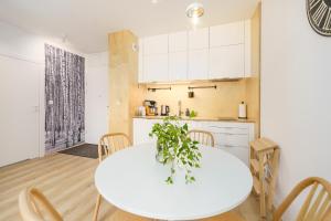 德茲維濟諾的住宿－Apartament BIRCH TREE SurfingBird Dźwirzyno，厨房以及带白色桌椅的用餐室。