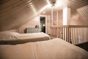 a attic bedroom with two beds and a staircase at Villa Lapintiira in Rovaniemi