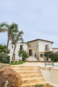 卡拉塔菲米的住宿－La Corte del Sole，棕榈树和楼梯前的房屋