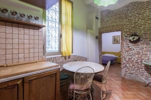 cocina con mesa, sillas y ventana en De'Gombruti, Bologna by Short Holidays, en Bolonia