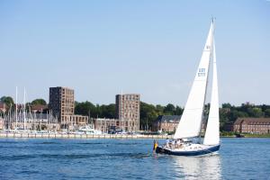 a sailboat in the water with a group of people on it at Ferienwohnung Strandmuschel in Flensburg, Sonwik in Flensburg