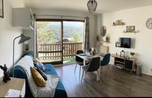 a living room with a bed and a table with chairs at U066 - Appartement cosy, vue sur la montagne à Gréolières in Gréolières